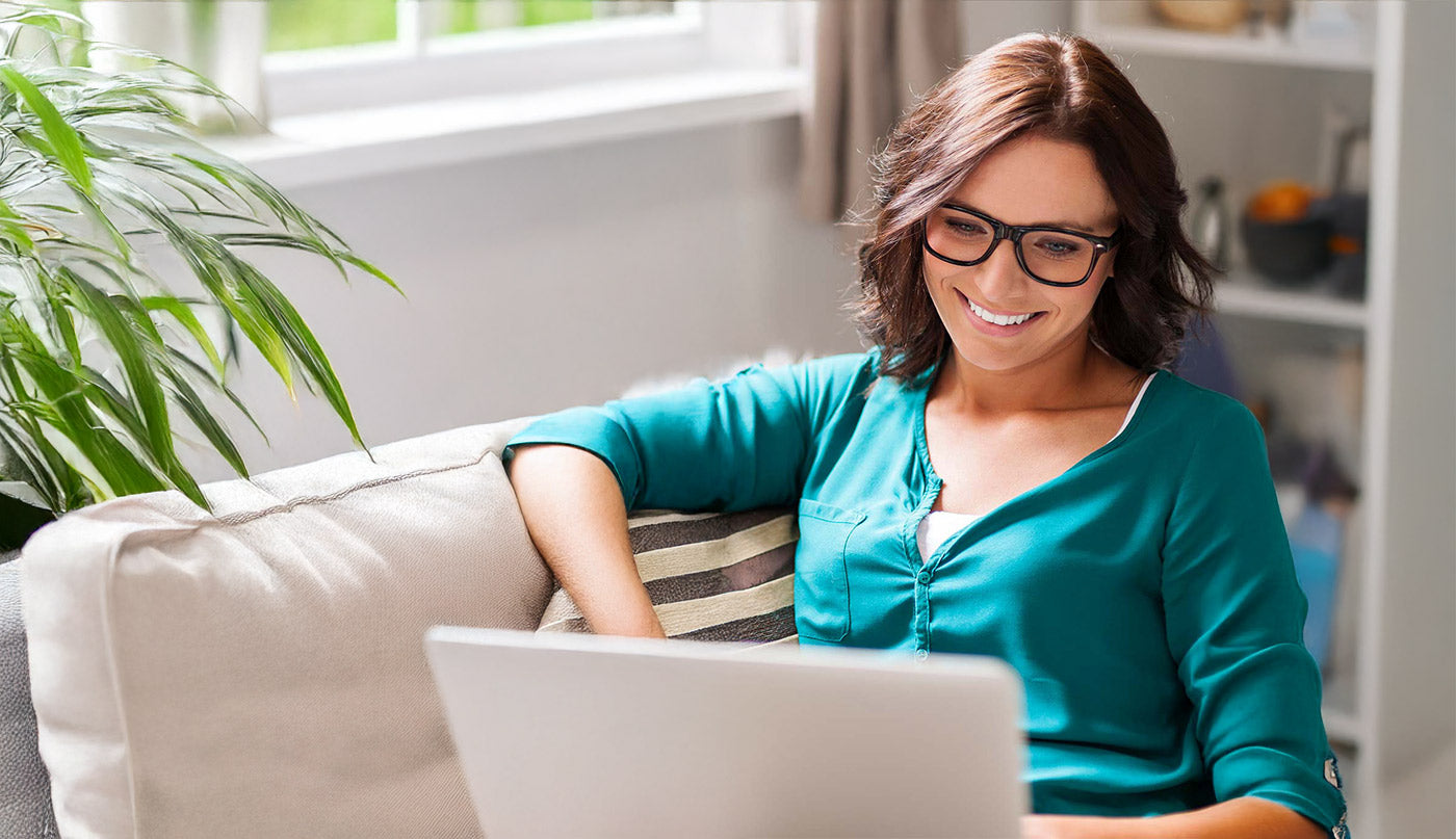 Doctor using a laptop on a couch in a home setting prescribing medicinal cannabis.