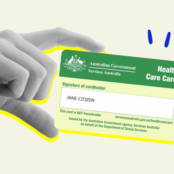 A stylized hand holding an Australian Government Services Australia health care card against a pale cream background with a yellow outline accent.