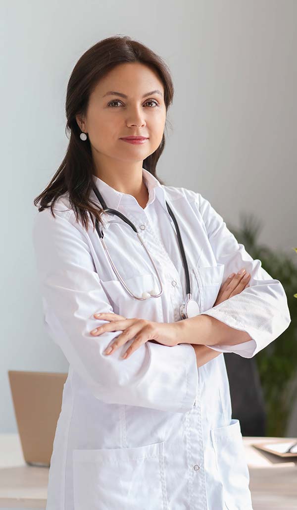 Cannabis doctor in a white coat with a stethoscope, standing indoors.