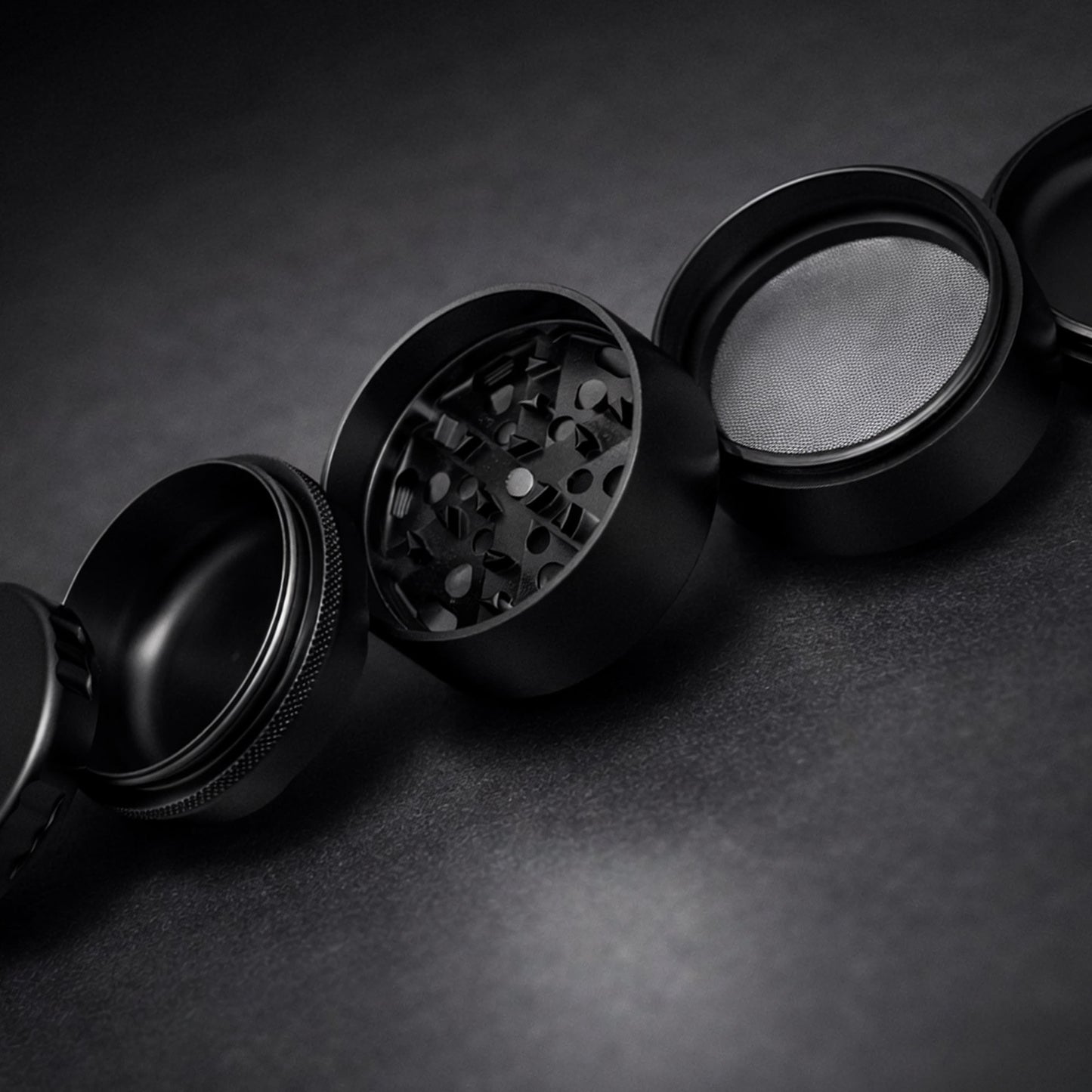 Black metal grinder on a dark textured surface
