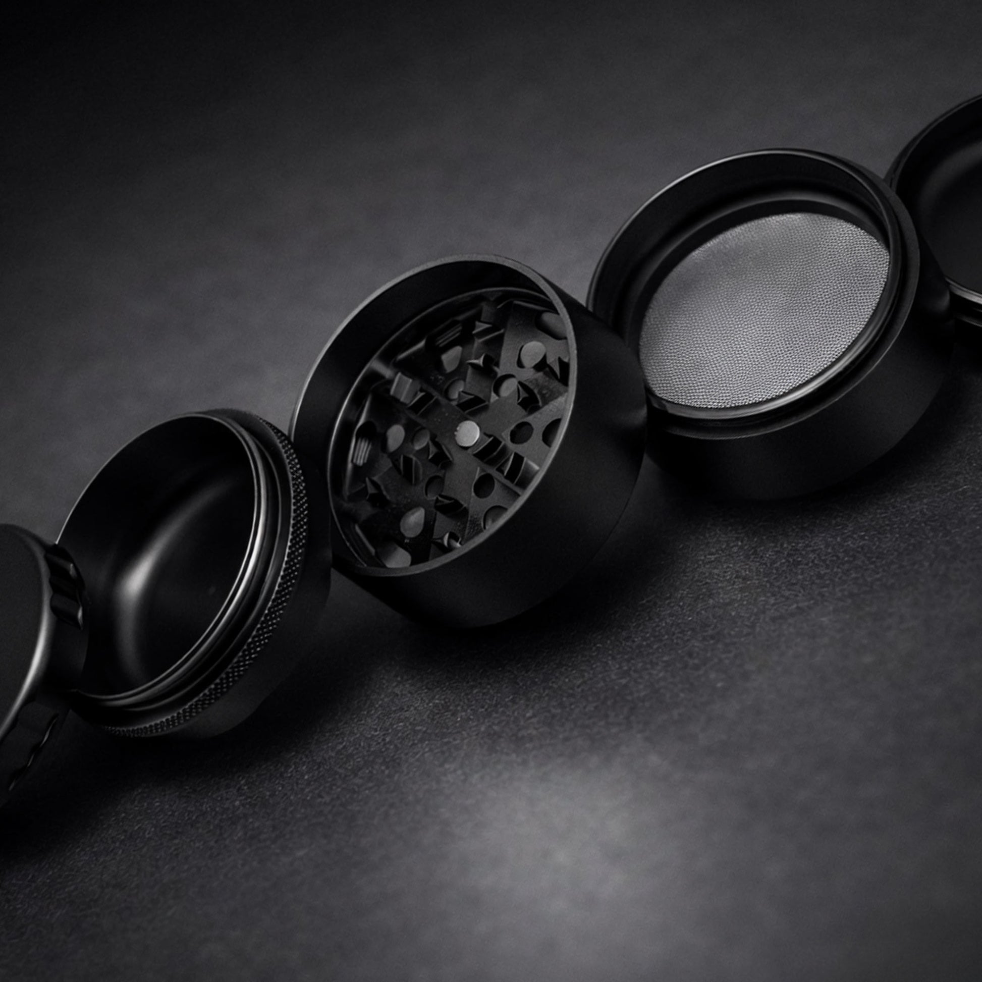 Black metal grinder on a dark textured surface