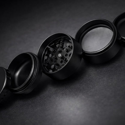 Black metal grinder on a dark textured surface
