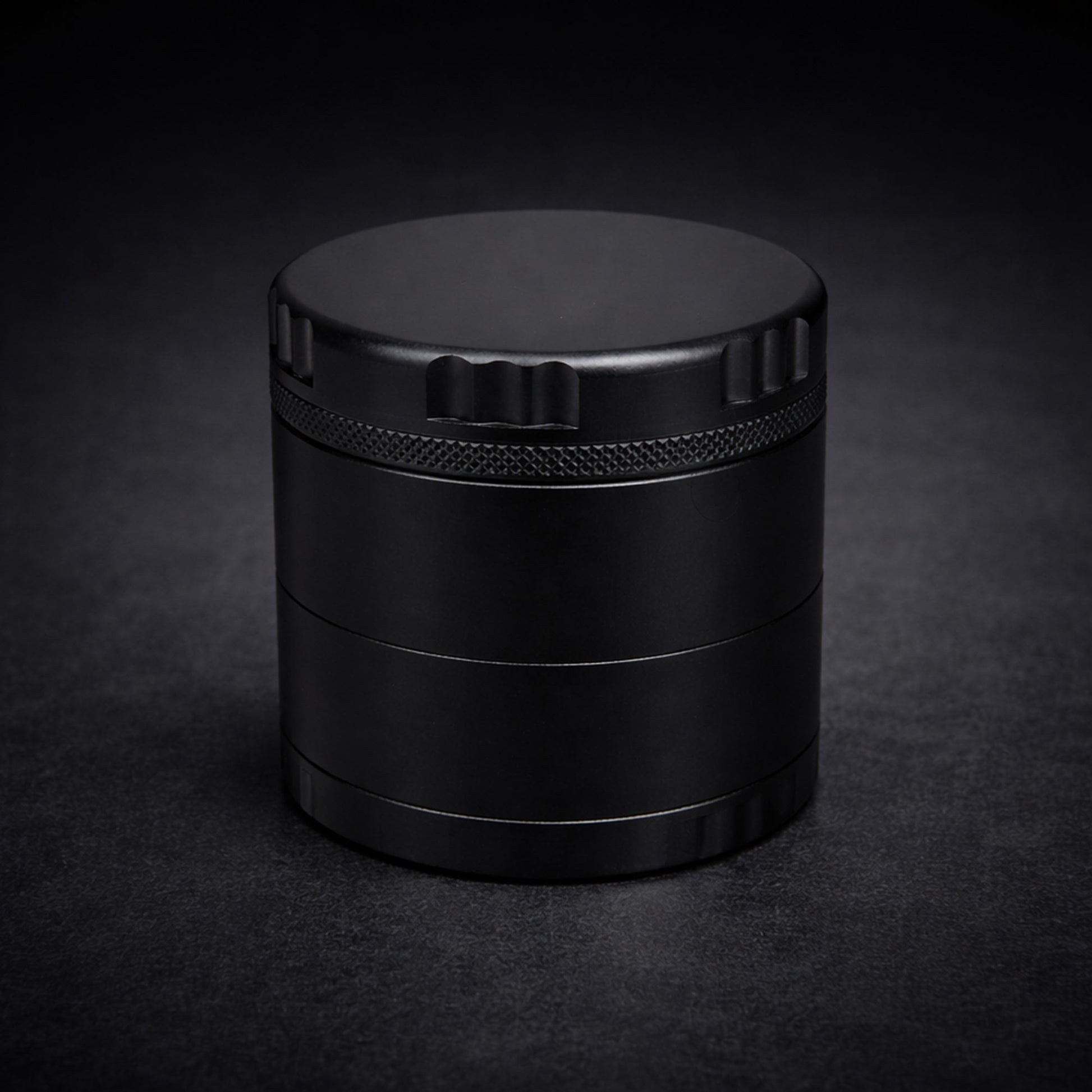 Black cylindrical grinder on a dark background