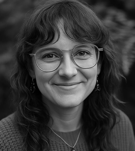 Black and white portrait of a woman wearing glasses with a blurred background