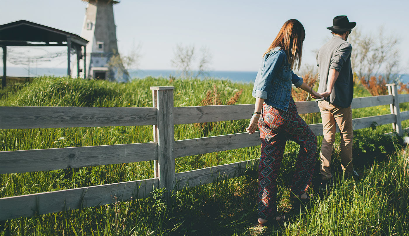 Two people walking along a wooden fence in a grassy field talking about Fibromyalgia
